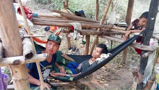 Francis, left, who is in charge of a Catholic student boarding compound in the Karen region of Myanmar, gives an IV to a man who is ill in the jungle after recent Burmese air attacks on their village. The sick man died two days later, while his son in the photo cared for him. 