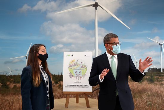 Alok Sharma, president of the U.N. Climate Change Conference, gestures next to Emma Khadeh and her winning art competition piece, during an event at Whitelee Windfarm, marking six months until the U.N. Climate Change Conference, outside Glasgow, Scotland, May 14, 2021. In a late August radio interview, Pope Francis confirmed that he will attend U.N. Climate Change Conference in Glasgow in November this year.