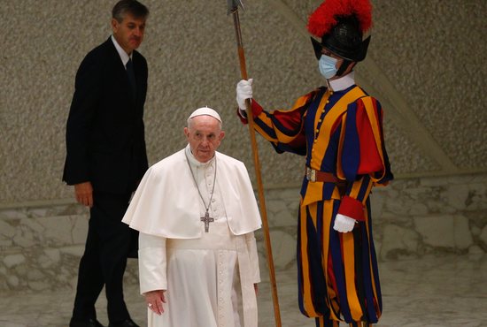 A Swiss Guard stands watch as Pope Francis arrives for his general audience in the Paul VI hall at the Vatican Sept. 22, 2021. Three members of the Pontifical Swiss Guard have hung up their halberds rather than be vaccinated against COVID-19, and three others were temporarily suspended in early October as they were completing the vaccination cycle, the spokesman for the guards told a Swiss newspaper.