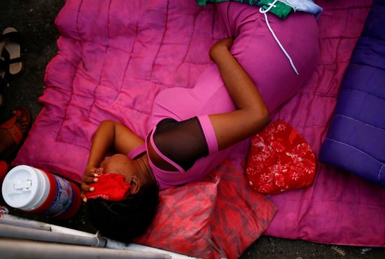 Rocena, a five-month pregnant migrant in Tapachula, Mexico, lies on the floor with a fever Dec. 4, 2021, while waiting in line for several days to obtain a humanitarian visa to transit through Mexico territory.