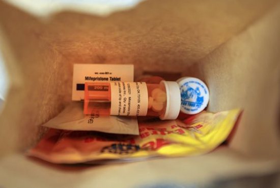 A paper bag containing the mifepristone and misoprostol pills used for a chemical abortion, follow-up instructions and small warming packs is seen at Trust Women clinic in Oklahoma City Dec. 6, 2021. 
