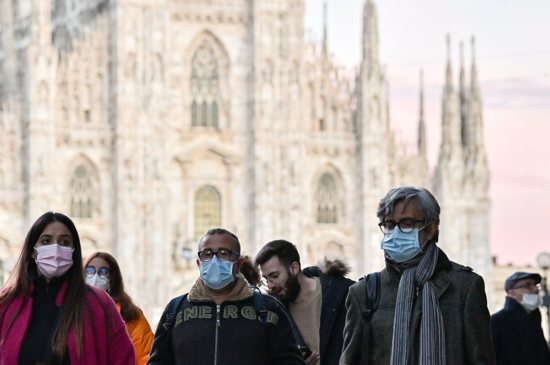The Catholic cathedral is seen in the background as people wear face masks amid the COVID-19 pandemic in Milan in this Nov. 28, 2021, file photo. A priest who is a member of the Pontifical Academy for Life wrote that wearing a high-filtering mask is a "little sacrifice" that can be offered to God.