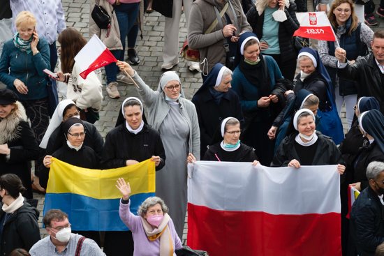 Nuns holds the national flags of Ukraine and Poland as Pope Francis leads the Angelus from the window of his studio overlooking St. Peter's Square at the Vatican Feb. 21, 2022.