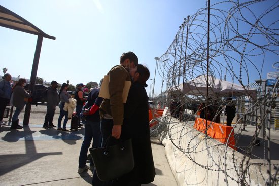 A Ukrainian woman embraces her boyfriend outside the San Ysidro Port of Entry at the U.S.-Mexico border in Tijuana, Mexico, March 10, 2022, as she waits for a humanitarian visa.