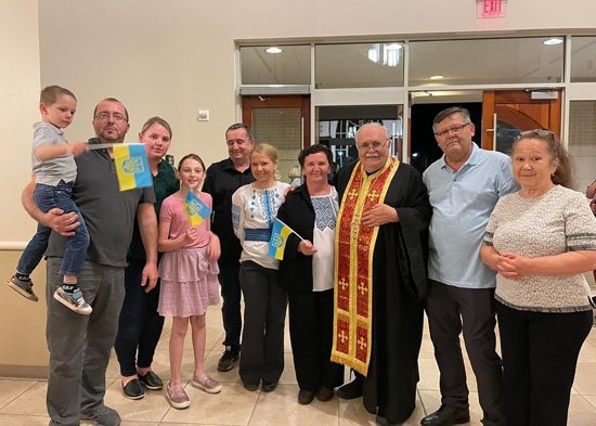 Msgr. William Bilinsky, in stole, gathers with Ukrainians who attended a Holy Hour for their embattled homeland March 15, 2022, at Mary Queen of Peace Church in Mandeville, La. Msgr. Bilinsky is a Ukrainian Catholic priest who was born in the U.S. but has relatives in Ukraine. He has collected more than $75,000 for Ukrainian relief.