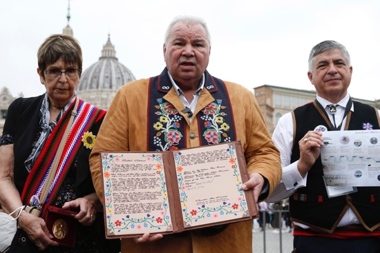 David Chartrand, president of the Manitoba Métis Federation, holds an agreement between the Métis Federation and the Canada government, as he speaks with journalists following a meeting of a Canadian Métis delegation with Pope Francis at the Vatican April 21, 2022. Chartrand said that the pope blessed the document.