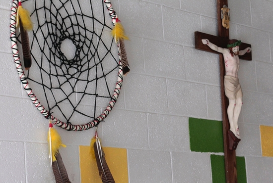 A dream catcher and crucifix are seen on the wall of a school on the Zuni Pueblo Indian reservation in New Mexico in this 2011 file photo.