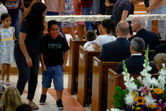 A child in Uvalde, Texas, cries during Mass at Sacred Heart Catholic Church May 29, 2022, as President Joe Biden, right, looks on. A gunman killed 19 children and two teachers at Robb Elementary School May 24.