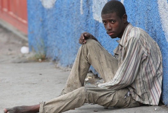 A young homeless man man is pictured in a file photo sitting on a sidewalk in Port-au-Prince, Haiti. The Vatican has released Pope Francis' message for the World Day of the Poor, which will be marked Nov. 13, 2022.