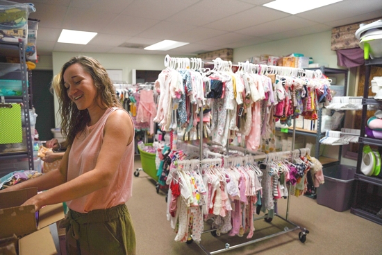 Emily Fitzgerald, a member of St. Thecla Parish in Clinton Township, Mich., helps out in the Lennon Pregnancy Center's clothing closet July 21, 2022. Fitzgerald has been volunteering at the center for almost a year, and wasn't deterred by the June 20 attack on the center.