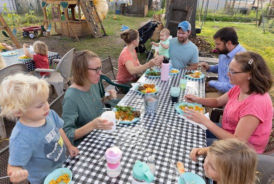 Clockwise from lower left, Solanus Miller, his mother, Leigh Miller, Crystal Hambley, her daughter, Zelie, and husband, Tyler, Daniel Hartig, his wife, Darray, and their daughter Edith share a meal in the back yard of the Miller home in Columbia Heights Sept. 19.