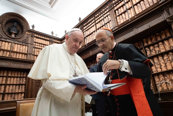 Pope Francis talks with Cardinal José Tolentino Calaca de Mendonca, Vatican archivist and librarian, during a ceremony in the Vatican Library Nov. 5, 2021. The Vatican Library, one of the world's oldest libraries, has launched a new scholarly journal to help promote high-quality research, dialogue across cultures and sharing knowledge, said Cardinal Mendonca. 
