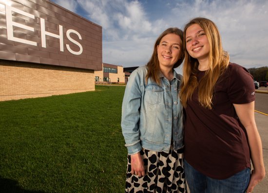 Alanna, left, and Lizzie Halloran stand in front of Edina High School, which they chose to attend so that they could follow the Gospel calling to be a light in the world.