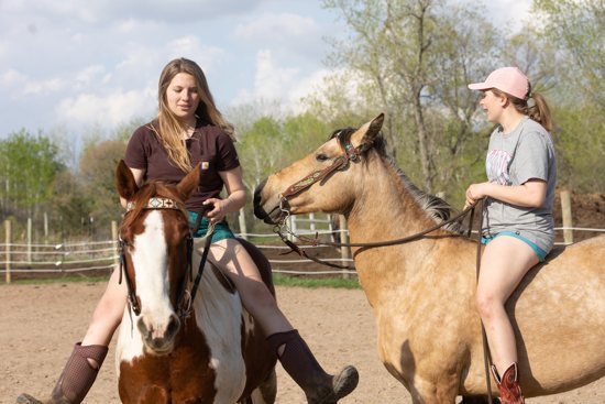 Lizzie, left, and Alanna enjoy an afternoon of riding their horses May 8 at a stable in Lake Elmo.